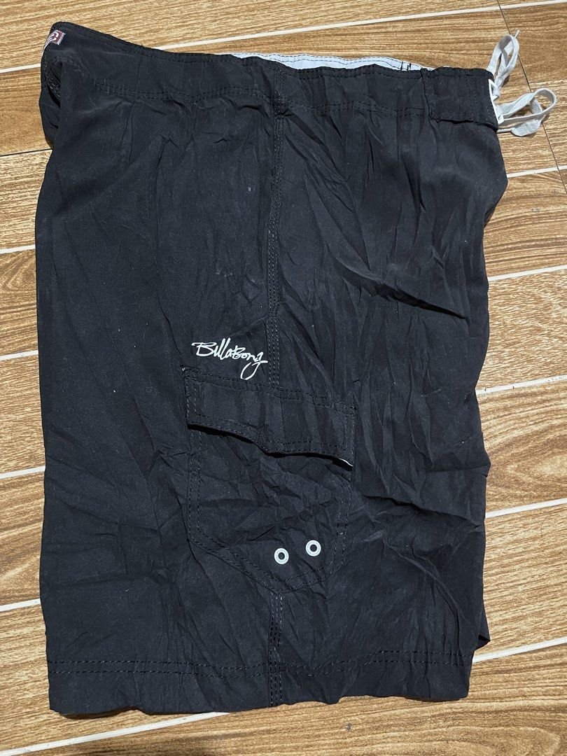 Billabong Black Board Shorts Size 36 (Category: Swim Trunks & Board Shorts) located in Mandaluyong City. Submitted by mark2pac (Listing ID 1469781918, Image 2). Description: - Brand: Billabong - Color: Solid Black - Size: 36 (tagged on inner label) - Material: 100% Polyester - Closure: Drawstring waist with white cords - Features: Side cargo pocket with metal grommets, embroidered Billabong script logo on hem and pocket - Origin: Made in China - 