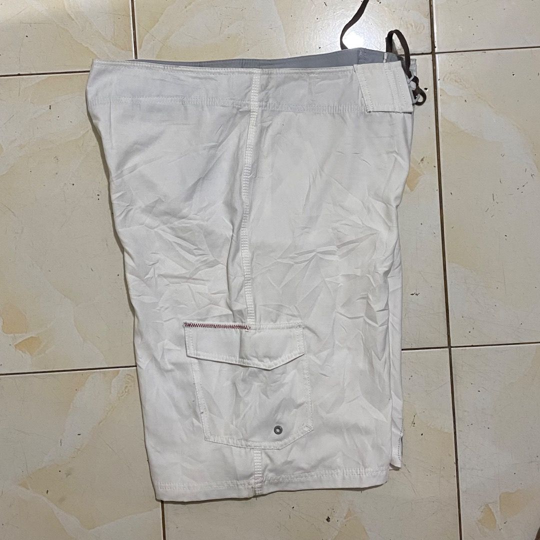 Billabong Boardshorts White Size 34 (Category: Swim Trunks & Board Shorts) located in Bacolod City. Submitted by jeybe112019 (Listing ID 1469893081, Image 2). Description: - Brand: Billabong - Size: 34 - Color: White with large grey and red logo graphics - Material: 100% polyester - Features: Velcro fly with front lace tie and right-side cargo pocket - Origin: Made in China - Condition: Excellent pre-owned condition.