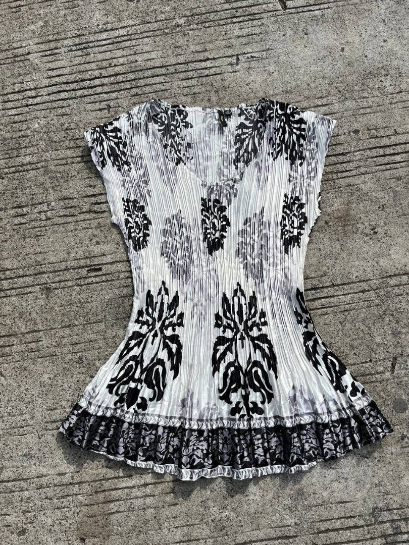 Black and White Pleated Damask Print Blouse (Category: Blouses) located in Caloocan City. Submitted by kimronnel (Listing ID 1469851338, Image 3). Description: - Stylish black and white patterned top with all-over pleats - Sleeveless with a flattering V-neck cut - Flared bottom hem featuring a detailed border - Made from 100% lightweight, easy-to-wash polyester - Versatile piece for casual or dressed-up outfits.