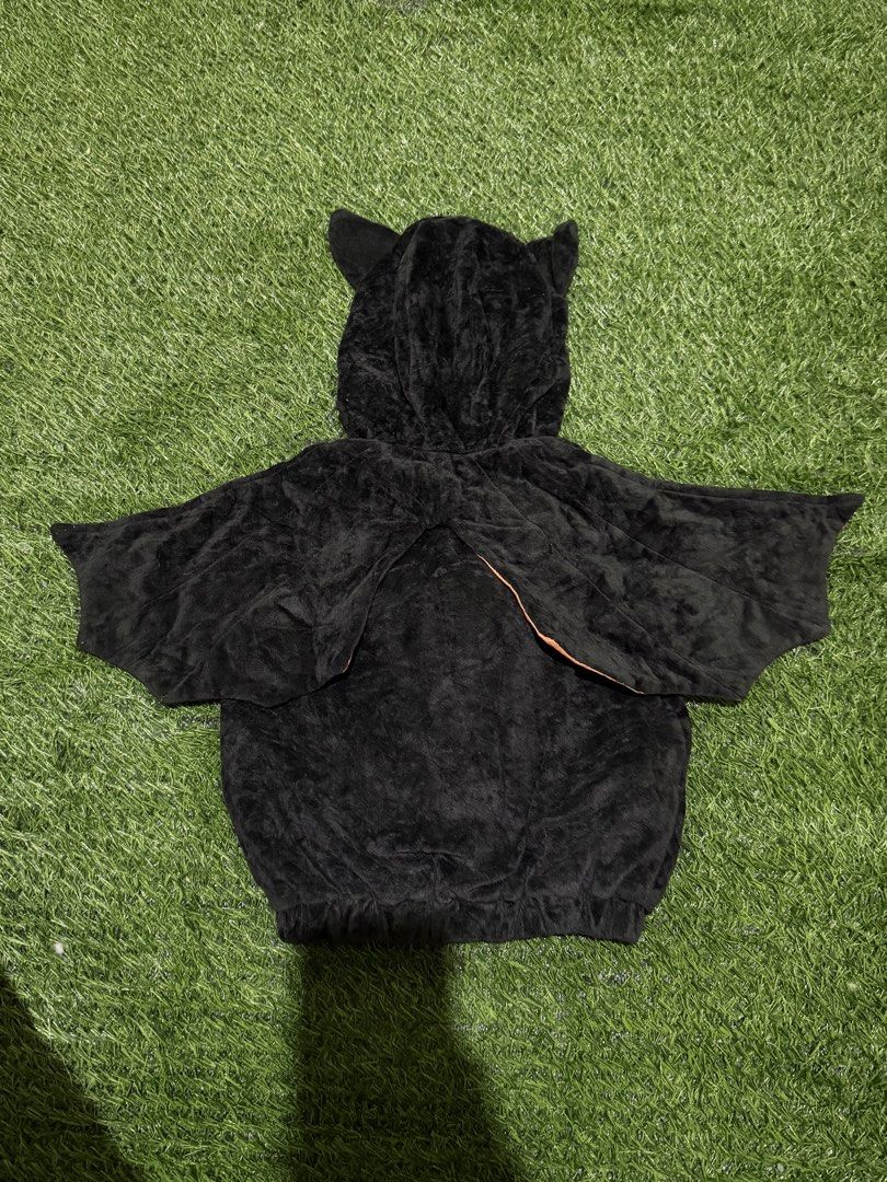Black bat hoodie costume (Category: Babies & Kids Fashion) located in San Fernando. Submitted by InvisibleMe (Listing ID 1469814529, Image 2). Description: - Adorable black fuzzy bat hoodie with plush material all over - Features sparkly orange wings attached to the sides - Hood comes with cute sewn-on bat ears - Three stylish orange buttons at the front neck area - Comfortable elastic band around the bottom hem - Ideal for Halloween, costume par