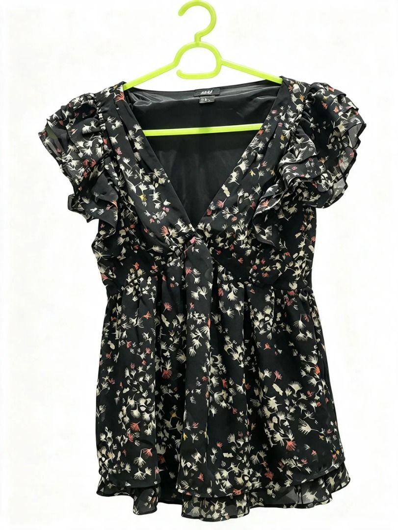 Black floral chiffon ruffle top V-neck blouse (Category: Blouses) located in San Jose del Monte. Submitted by shopkcscloset (Listing ID 1469823461, Image 1). Description: - Color & Pattern: Black with an all-over small floral print - Material: Lightweight chiffon with comfortable inner lining - Details: V-neckline with front tie and layered ruffle cap sleeves - Fit: Flowy fit with a stylish layered hem - Versatility: Great for casual days or pair