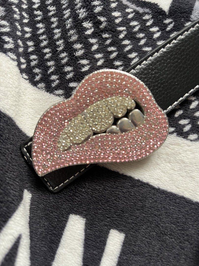 Black Leather Belt with Rhinestone Lips Buckle (Category: Belts) located in Silang. Submitted by kristan.asian (Listing ID 1469891610, Image 3). Description: - Color: Black leather with white contrast stitching - Feature: Stunning lips-shaped statement buckle covered in pink and silver rhinestones with metallic grill teeth - Fit: Multiple sizing holes for adjustable comfort - Style: Fun and trendy accessory to elevate casual or edgy outfits - Con