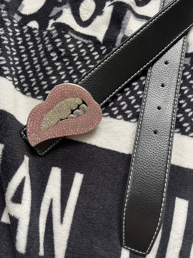 Black Leather Belt with Rhinestone Lips Buckle (Category: Belts) located in Silang. Submitted by kristan.asian (Listing ID 1469891610, Image 2). Description: - Color: Black leather with white contrast stitching - Feature: Stunning lips-shaped statement buckle covered in pink and silver rhinestones with metallic grill teeth - Fit: Multiple sizing holes for adjustable comfort - Style: Fun and trendy accessory to elevate casual or edgy outfits - Con