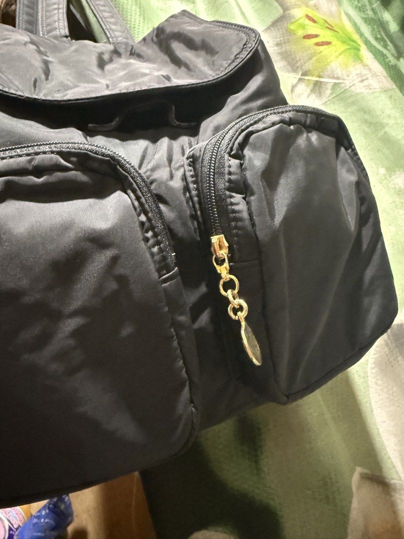 SONIA RYKIEL Backpack with Gold Zippers (Category: Backpacks) located in Opol. Submitted by great_finds_kollexion (Listing ID 1469879492, Image 3). Description: - Color: Classic Black - Material: Lightweight, durable nylon - Closure: Flap top with drawstring - Pockets: Two exterior zippered front pockets with gold-tone chain pull charms - Straps: Adjustable with buckle details - Condition: Clean interior and exterior, ready for use - Ideal for: D