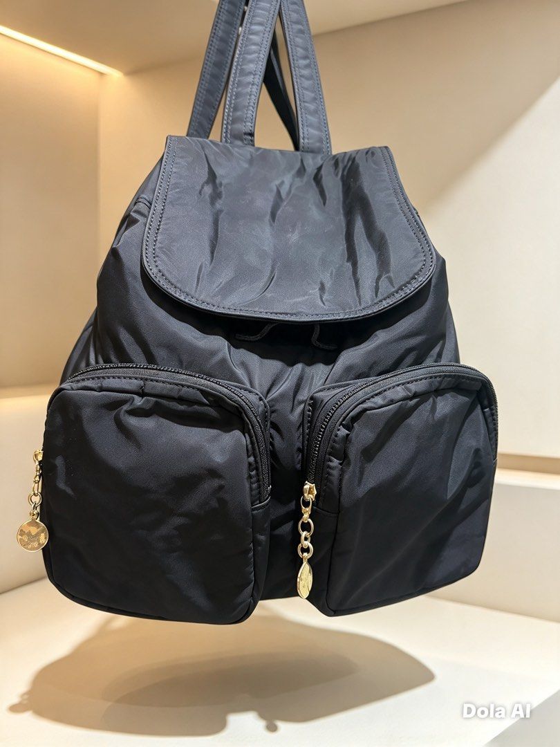 SONIA RYKIEL Backpack with Gold Zippers (Category: Backpacks) located in Opol. Submitted by great_finds_kollexion (Listing ID 1469879492, Image 1). Description: - Color: Classic Black - Material: Lightweight, durable nylon - Closure: Flap top with drawstring - Pockets: Two exterior zippered front pockets with gold-tone chain pull charms - Straps: Adjustable with buckle details - Condition: Clean interior and exterior, ready for use - Ideal for: D