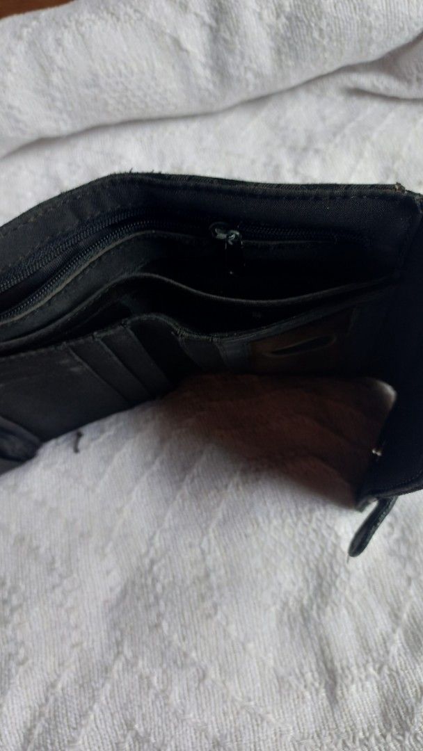 Black patterned trifold wallet with buckle strap (Category: Wallets & Card holders) located in Rizal. Submitted by mayra74 (Listing ID 1469766560, Image 3). Description: - Color: Black - Design: Textured exterior with decorative strap and buckle accent - Closure: Secure magnetic snap - Interior Features: Multiple card slots, clear ID window, slip pockets, and zippered coin compartment - Size: Compact and fits easily into any handbag - Condition: 