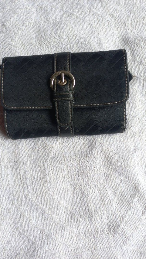 Black patterned trifold wallet with buckle strap (Category: Wallets & Card holders) located in Rizal. Submitted by mayra74 (Listing ID 1469766560, Image 1). Description: - Color: Black - Design: Textured exterior with decorative strap and buckle accent - Closure: Secure magnetic snap - Interior Features: Multiple card slots, clear ID window, slip pockets, and zippered coin compartment - Size: Compact and fits easily into any handbag - Condition: 