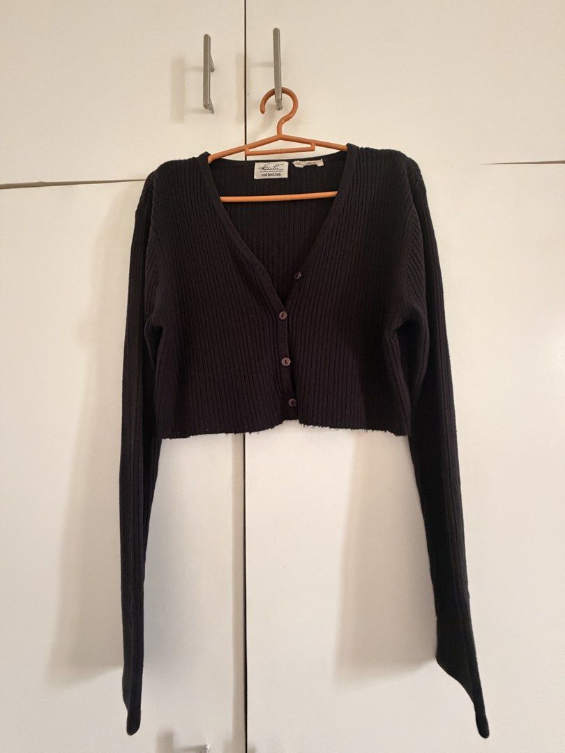 Black Ribbed Knit Crop Cardigan (Category: Coats, Jackets and Outerwear) located in Marikina City. Submitted by _bananahanaa (Listing ID 1469803404, Image 1). Description: - Style: Reworked, Cropped ribbed knit cardigan with a fitted silhouette - Details: Deep V-neckline, long sleeves, and front button closure with 4 matching dark buttons - Material: Soft and stretchy fabric for comfortable wear.