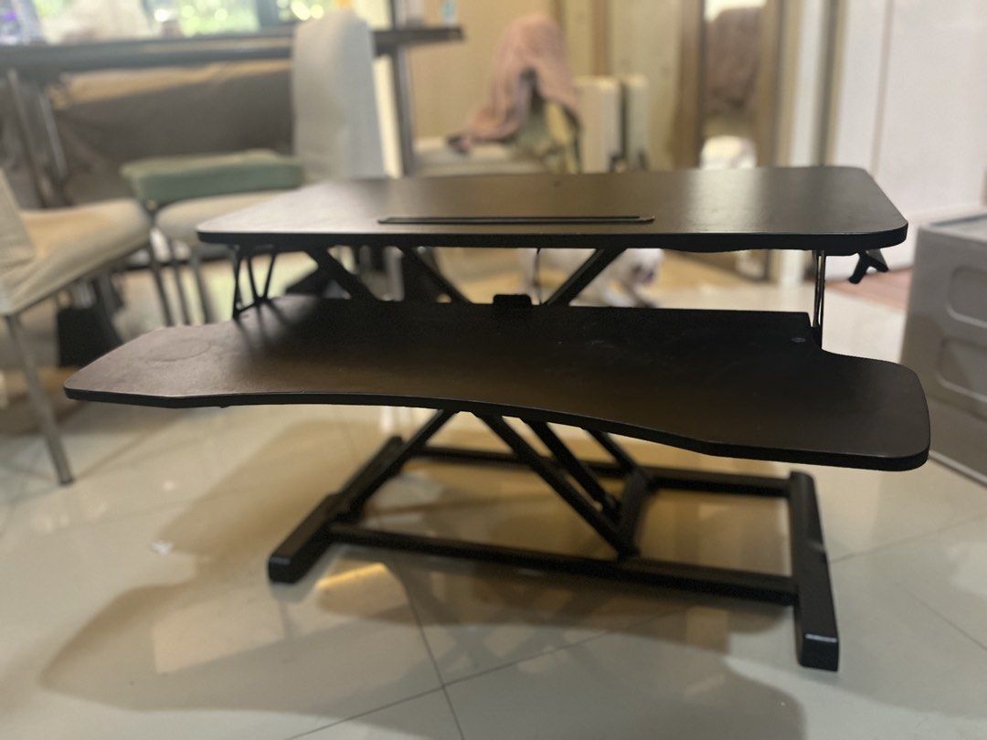 Black sit-stand adjustable desktop converter riser (Category: Office Furniture & Fixtures) located in Quezon City. Submitted by jsymagno (Listing ID 1469802646, Image 3). Description: - Black sit-stand desk converter with smooth height adjustments - Two-tier design separates your monitor and keyboard setup - Built-in slot on top platform holds phones and tablets upright - Sturdy X-frame metal base for reliable daily use - Minor surface wear from 