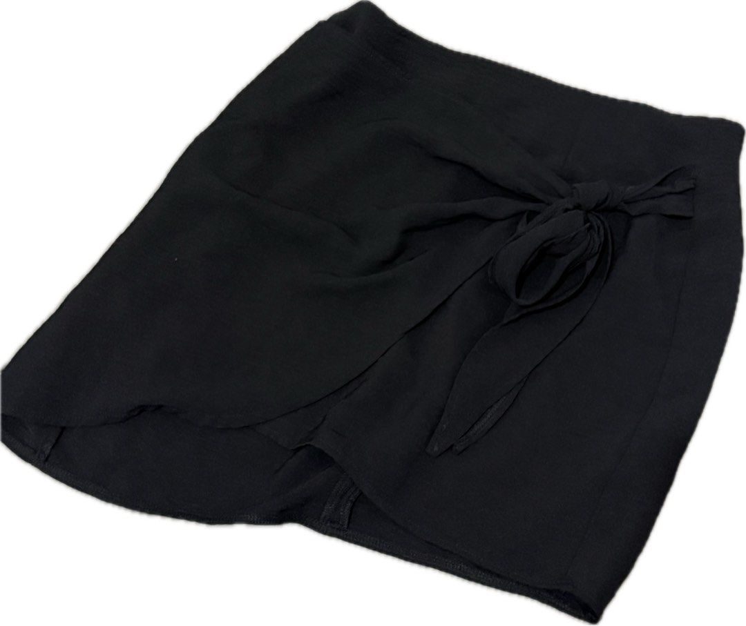 Black wrap skirt (Category: Skirts) located in Quezon City. Submitted by mintconditionph (Listing ID 1469905020, Image 1). Description: - Color: Solid black - Design: Wrap skirt style with built-in shorts underneath - Material: Soft, lightweight fabric with a nice drape - Details: Decorative front side tie knot and clean hemlines - Versatility: Easy to pair with casual tees or elegant blouses.
