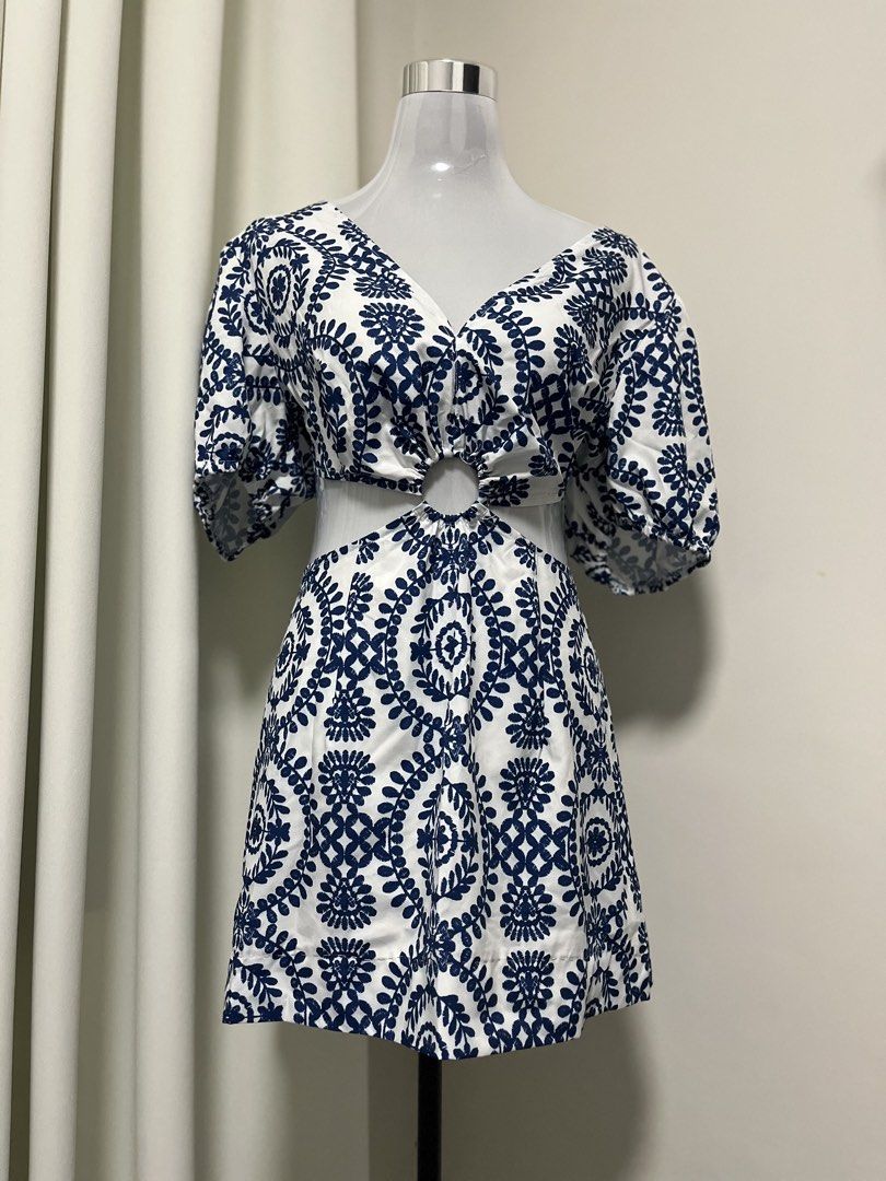Blue and White Patterned Cutout Dress (Category: Dresses) located in Angeles City. Submitted by pinkpool (Listing ID 1469766132, Image 1). Description: - Color & Pattern: White with all-over dark blue floral embroidery - Design: V-neckline, short puff sleeves, and trendy midriff cutout with a center metal ring detail - Material: Lightweight and comfortable cotton - Closure: Convenient back zip - Condition: Excellent/like-new (worn once, freshly w