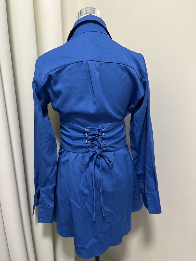 Blue Button Up Dress with Lace Up Back (Category: Dresses) located in Angeles City. Submitted by pinkpool (Listing ID 1469771447, Image 2). Description: Vibrant royal blue shirt dress featuring a fitted ruched bodice, lace-up corset back, and a flared skater hem. Made from a smooth, slightly stretchy fabric with long sleeves and a pointed collar. Perfect for a chic, standout look!.