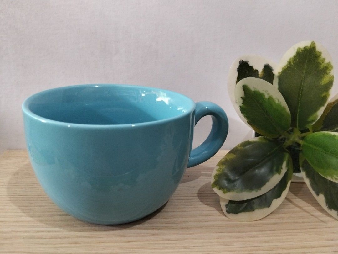Blue Ceramic Mug (Category: Coffee & Tea Tableware) located in Caloocan City. Submitted by agr_shop (Listing ID 1469835651, Image 2). Description: - Color: Bright blue with a smooth glazed finish - Special Feature: Cute white yeti sitting at the bottom for a fun surprise - Design: Comfortable side handle for easy grip - Condition: Clean interior, no stains or scratches - Perfect for: Coffee, tea, or as a gift.
