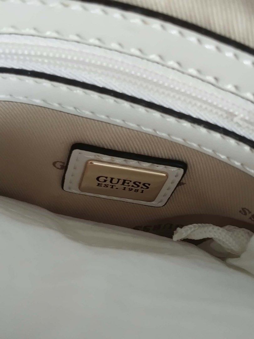 [BNWT] GUESS Noelle Camera Crossbody Bag (Category: Luxury Bags & Wallets) located in Valenzuela. Submitted by wiskyyyyy (Listing ID 1469865807, Image 3). Description: Condition: Brand New with Tags & protective plastic intact 📍 Style Code: BD787913 (Guaranteed Authentic) Product Details: Color: Dove Logo (Off-White / Beige print with gold hardware) Material: Premium PU leather with iconic GUESS 4G monogram Zip closure with adjustable chain-acce