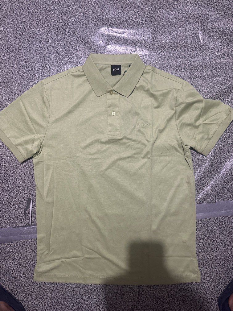 BOSS Green Polo Shirt (Category: Tshirts & Polo Shirts ) located in Manila. Submitted by thrift.zone1 (Listing ID 1469857673, Image 1). Description: - Brand: BOSS - Color: Green - Style: Casual short-sleeve polo with classic collar and button placket - Details: Subtle embroidered logo on left chest, tag attached near the collar - Fabric: Lightweight and breathable - Condition: Brand new with tags.