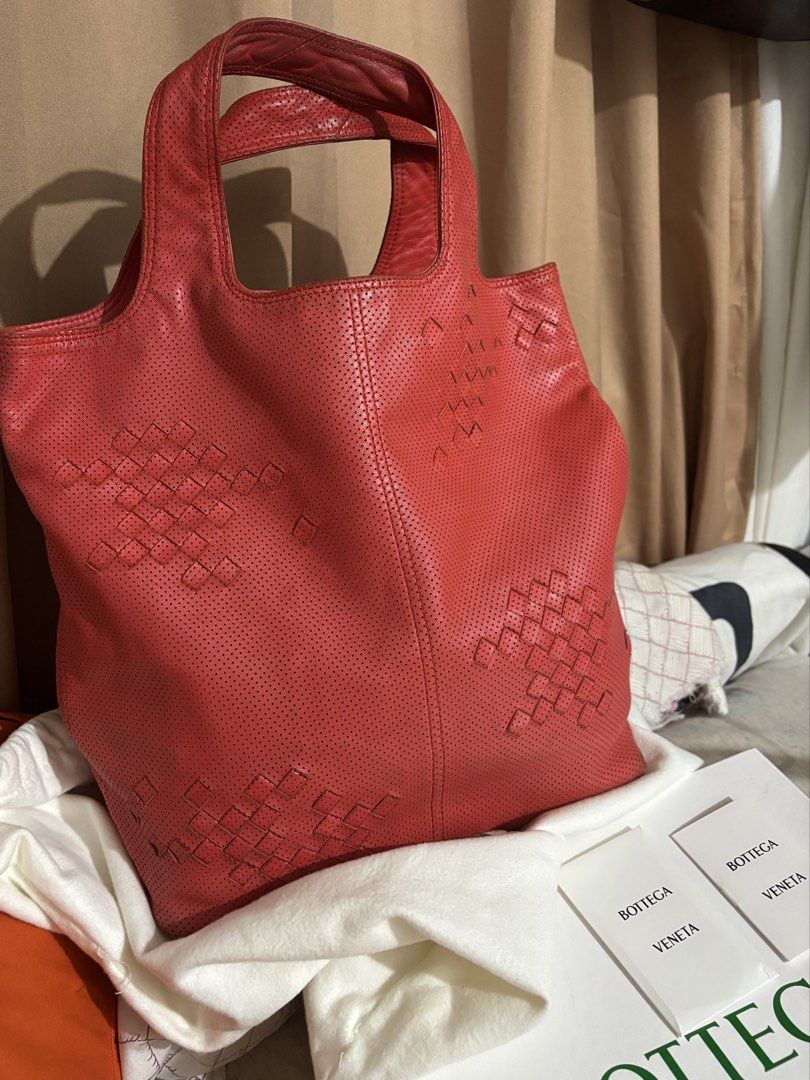 Bottega Veneta (Category: Tote Bags) located in Caloocan City. Submitted by rossvault2 (Listing ID 1469871833, Image 2). Description: - Brand: authentic Bottega Veneta - Style: Red perforated leather tote bag with subtle woven leather square pattern - Handles: Double shoulder handles - Interior: Fabric lining with zip pocket - Origin: Made in Italy - Inclusions: Original white box, dust bag, care cards, and receipt paperwork - Condition: Guarante