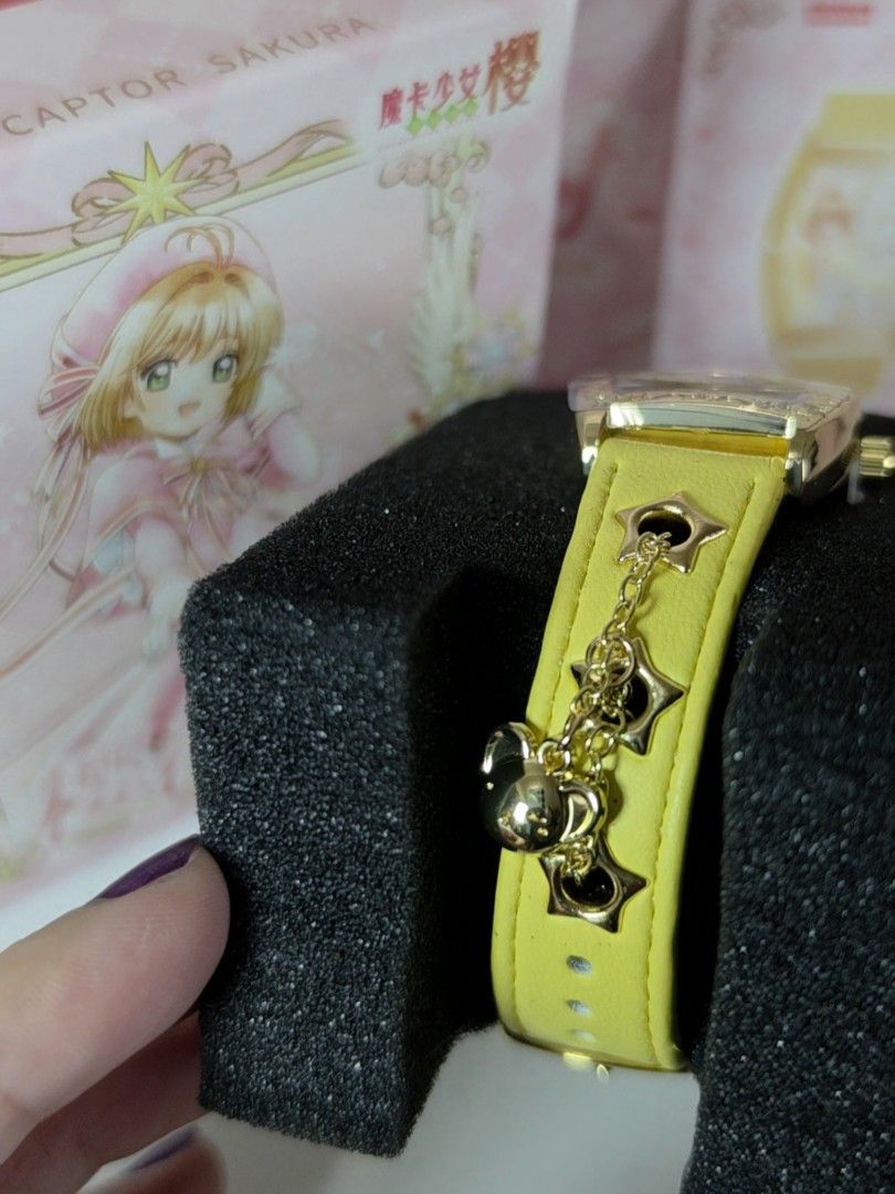 BOXFUN Cardcaptor Sakura Yellow Watch (Category: Women's Watches) located in Pasig City. Submitted by ccsakura4 (Listing ID 1469913580, Image 2). Description: - Brand: Boxfun (Model 02 - Cardcaptor Sakura edition) - Case: Gold-tone rectangular case with a sparkly bezel - Dial: Mother-of-pearl dial featuring a Sakura illustration and crystal star hour markers - Strap: Yellow leather strap with star cutouts, dangling star charm, and Kero-chan charm