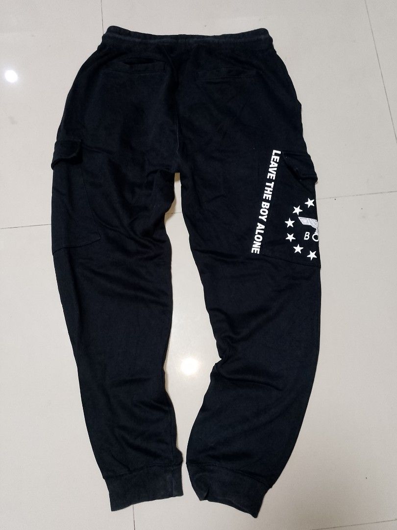 Boy London Black Cargo Sweatpants Joggers (Category: Joggers) located in Manila. Submitted by mjthrifted_second (Listing ID 1469833704, Image 2). Description: Code 10 - Brand: Boy London (Authentic) - Color: Black - Style: Sweatpants with cargo pockets, drawstring waist, and elastic cuffs - Details: Eagle logo and stars graphic on the right leg - Back Print: 'LEAVE THE BOY ALONE' text on the back leg - Condition: Branded drawstrings and interior 