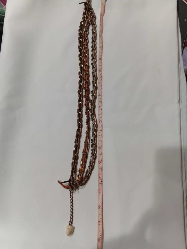 Bronze Chain Layered Necklace with Leather Weaving (Category: Necklaces) located in Caloocan City. Submitted by mma_222 (Listing ID 1469802579, Image 3). Description: - Metal chain multi-strand necklace with woven leather threads in earthy tones - Total length measures around 17 inches with an adjustable chain - Sits around the collarbone.