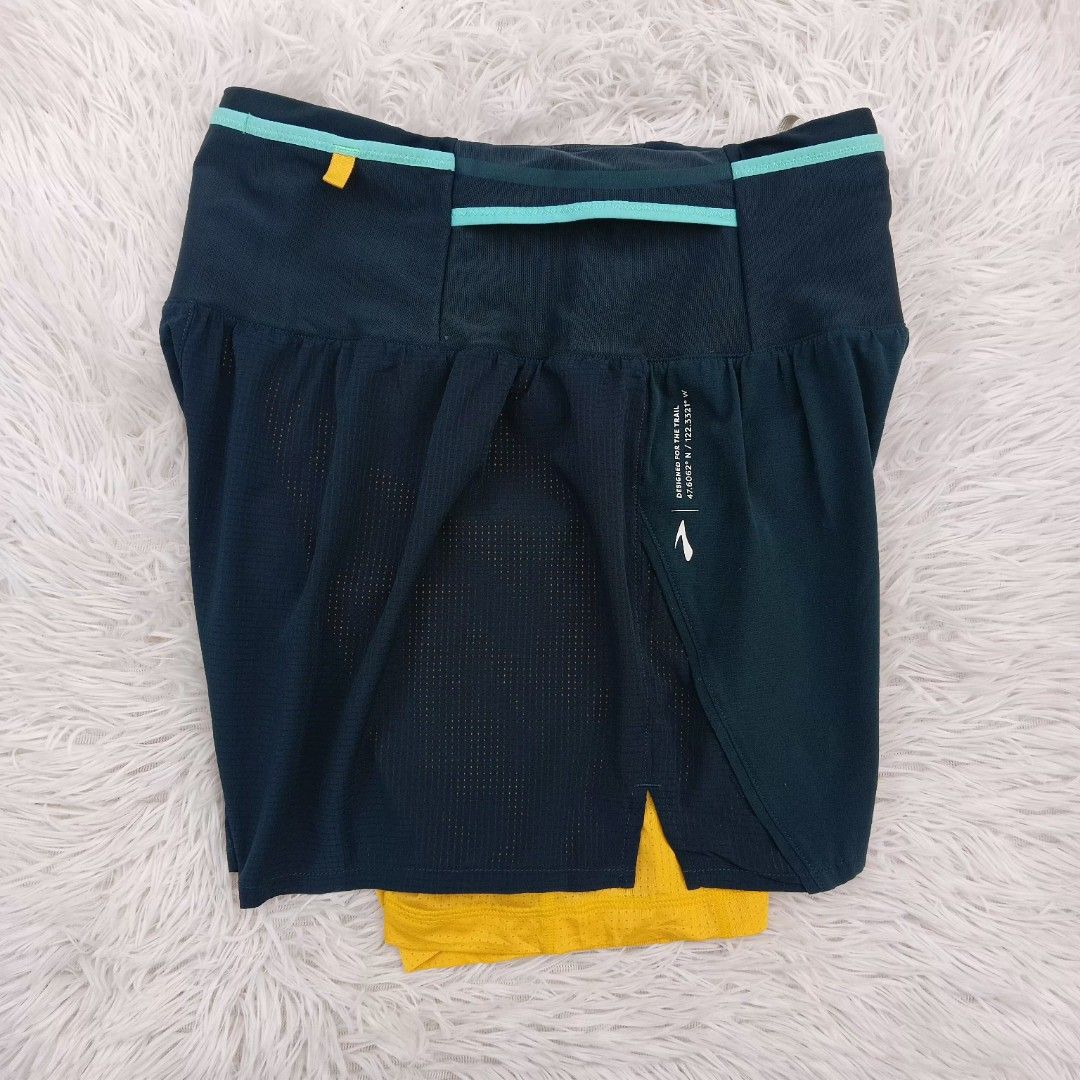 Brooks Trail Running Shorts Size S (Category: Shorts) located in Gattaran. Submitted by thrift_wiseph (Listing ID 1469854403, Image 2). Description: - Brand: Brooks - Item: Trail Running Shorts - Color: Dark blue with yellow inner lining and teal trim - Size: S - Material: Lightweight perforated fabric for outdoor runs - Storage: Built-in waistband pockets - Design: Trail coordinate graphics printed on the back - Origin: Made in Vietnam.