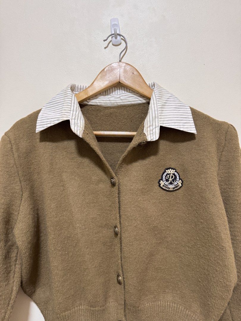 Brown Collared Cardigan with Crest Patch (Category: Coats, Jackets and Outerwear) located in Manila. Submitted by seayouncey (Listing ID 1469929498, Image 3). Description: - Style: Preppy academic vibe, easy to throw on over basic tees - Design: Button-up front with ornate buttons and embroidered crest patch on the chest - Details: Attached striped shirt collar, long sleeves with puffed shoulders - Fit: Cropped length with ribbed hem and cuffs - 