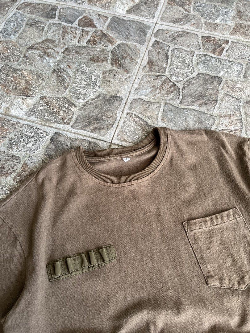 Brown Utility Tee Military Cargo Pockets Size XL (Category: Tshirts & Polo Shirts ) located in Quezon City. Submitted by reluxefinds2025 (Listing ID 1469805728, Image 2). Description: - Size: XL - Color: Brown with olive green nylon details - Style: Tactical cargo streetwear - Features: Chest pocket, small utility loops, and two lower pockets - Material: Heavy cotton with a wash look and relaxed fit - Condition: Clean.