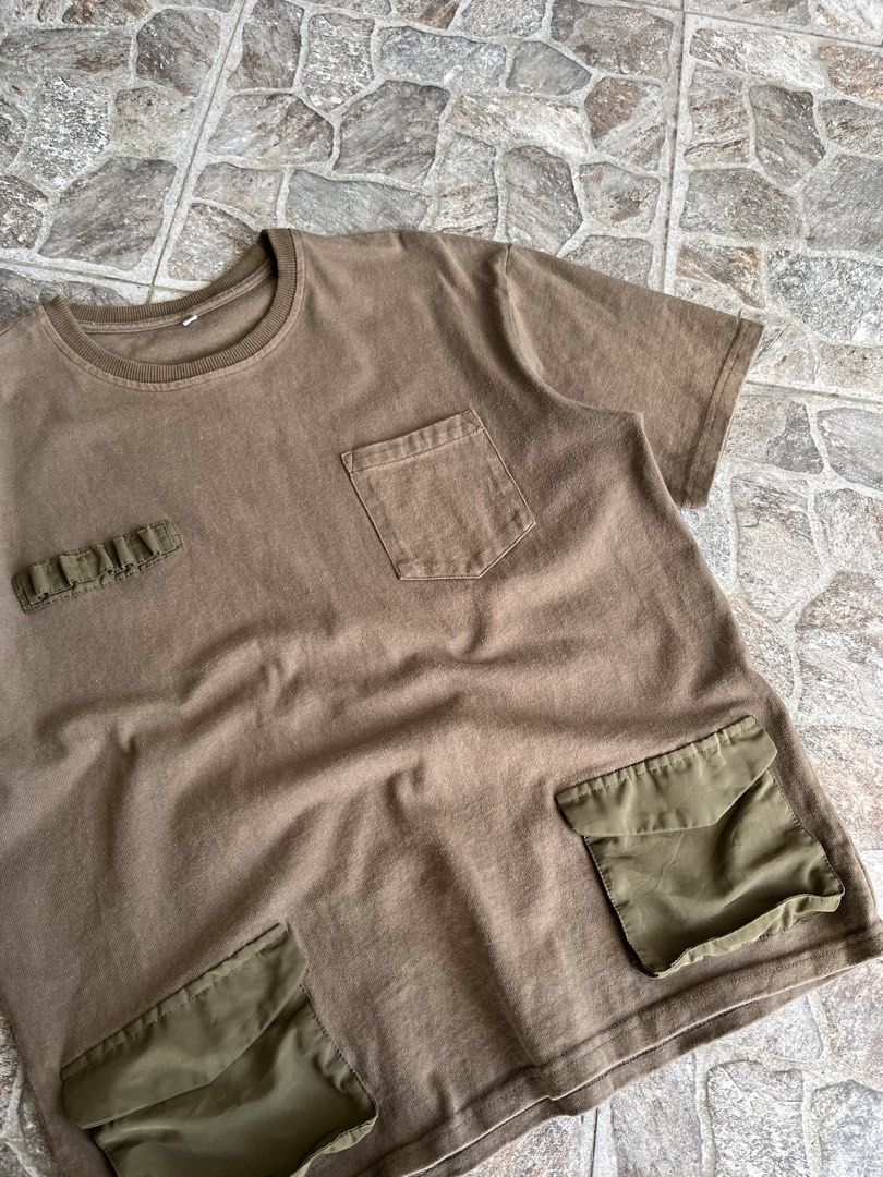 Brown Utility Tee Military Cargo Pockets Size XL (Category: Tshirts & Polo Shirts ) located in Quezon City. Submitted by reluxefinds2025 (Listing ID 1469805728, Image 3). Description: - Size: XL - Color: Brown with olive green nylon details - Style: Tactical cargo streetwear - Features: Chest pocket, small utility loops, and two lower pockets - Material: Heavy cotton with a wash look and relaxed fit - Condition: Clean.