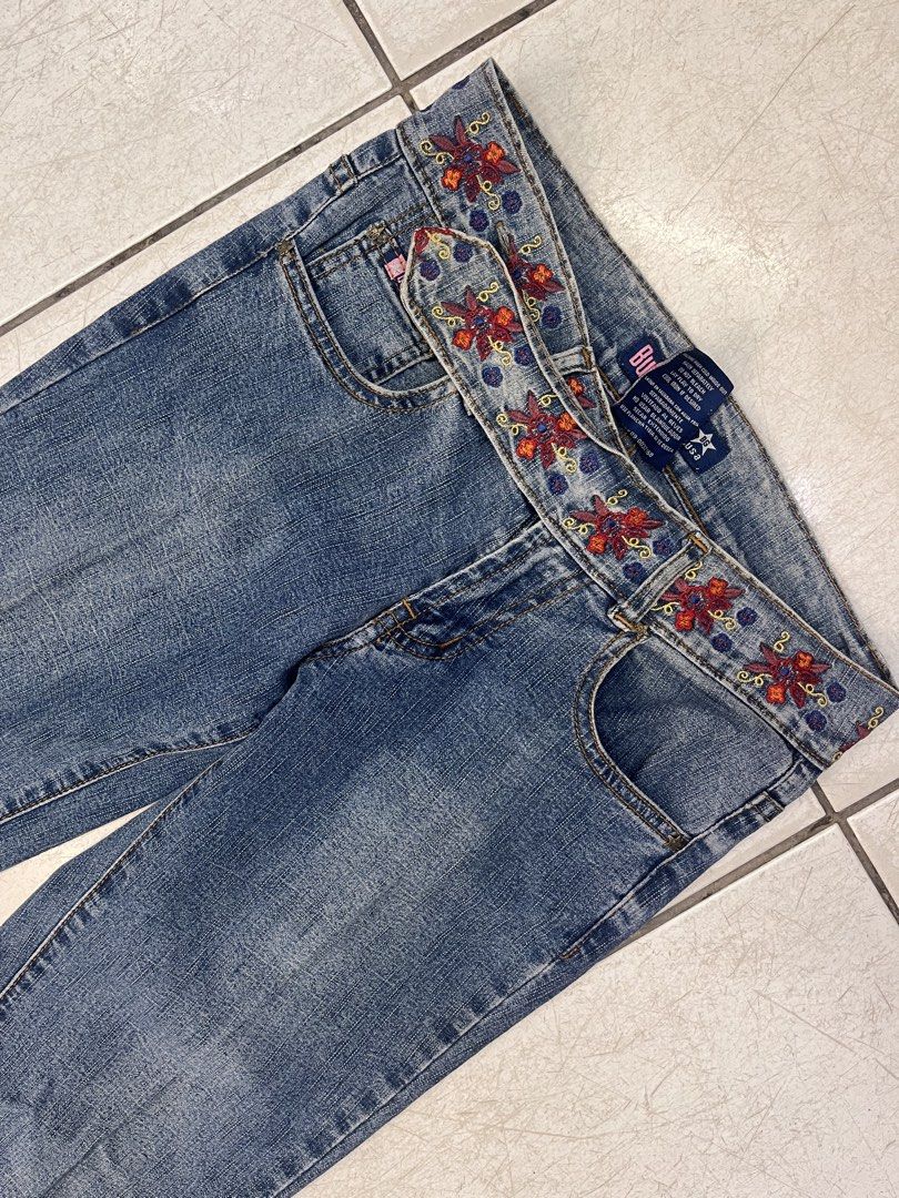 Bubblegum American Flavour Embroidered Bootcut Jeans (Category: Jeans) located in Dagupan City. Submitted by shanadongsb (Listing ID 1469864218, Image 2). Description: - Brand/Style: Bubblegum bootcut jeans in blue denim - Size: 3/4 - Design details: Red and blue floral embroidery on the waistband and bottom cuffs - Pockets: Two front pockets and two back pockets with stitched detailing - Material: 92% cotton, 8% spandex blend for a slight stretc