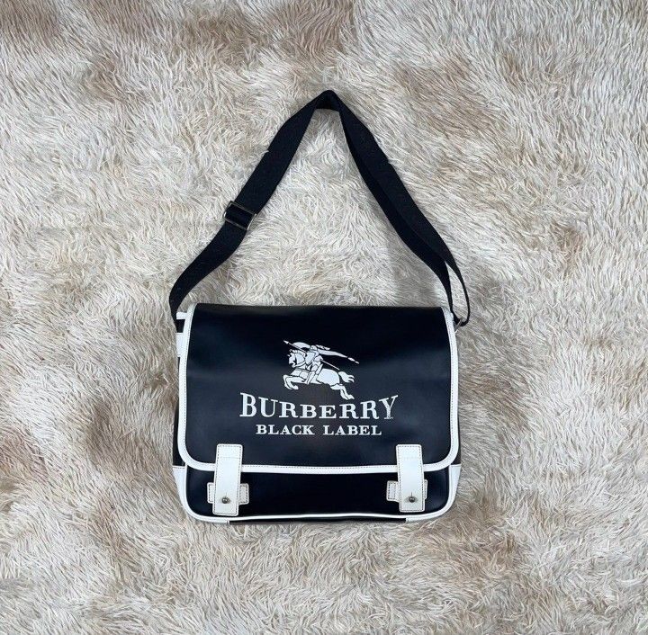 Burberry Black Label Messenger Bag (Category: Sling Bags) located in Dasmarinas. Submitted by classic.threads (Listing ID 1469782340, Image 1). Description: Burberry Black Label Messenger Bag Details: -Excellent Condition -Black -Big Logo in Front -Signs Of Usage - Embroid Burberry black label on strap -Adjustable Strap ΑΞ -2 big Pockets in front and back, 3 small inside pockets. -Leather -Slight Tattered on right inside. Size: *Flat Measurements
