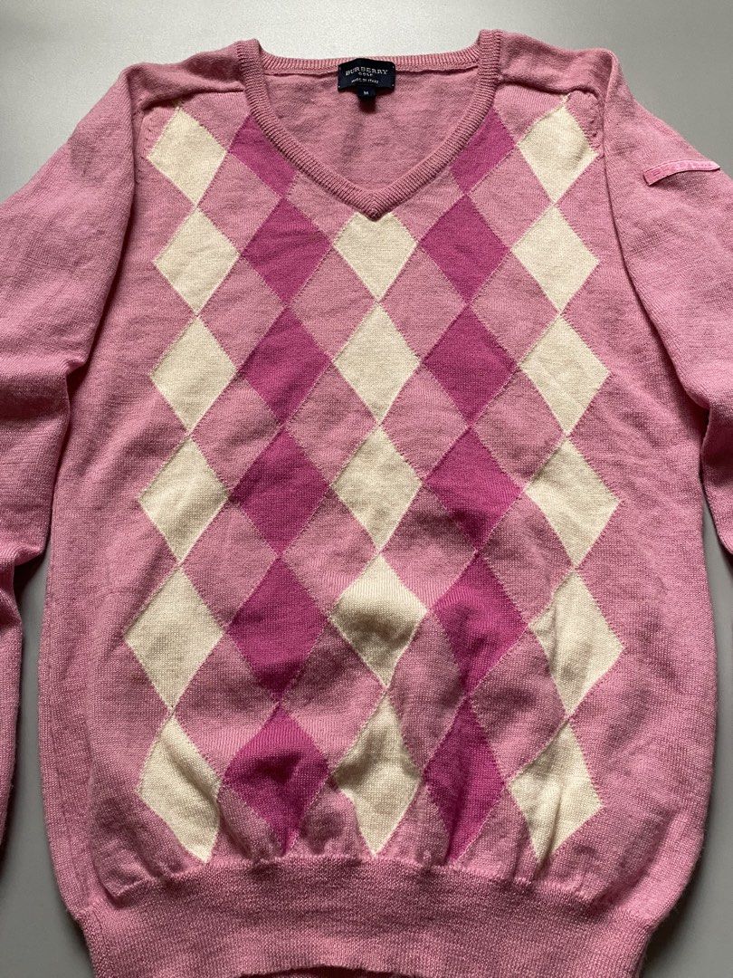 Burberry golf pink argyle V-neck sweater, (Category: Luxury Apparel) located in Cebu City. Submitted by dfindss. (Listing ID 1469846005, Image 2). Description: This item is an authentic Burberry pink argyle V-neck sweater, known for its classic preppy and knitwear aesthetic. It features a multi-tone pink, white, and magenta diamond pattern across the front panel..