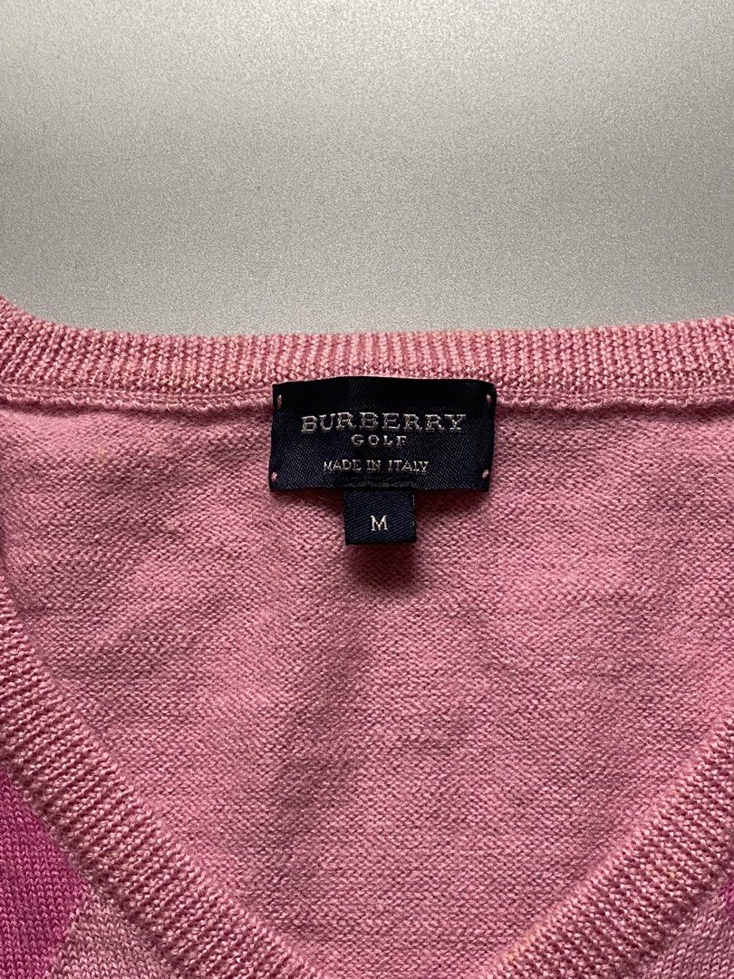 Burberry golf pink argyle V-neck sweater, (Category: Luxury Apparel) located in Cebu City. Submitted by dfindss. (Listing ID 1469846005, Image 3). Description: This item is an authentic Burberry pink argyle V-neck sweater, known for its classic preppy and knitwear aesthetic. It features a multi-tone pink, white, and magenta diamond pattern across the front panel..