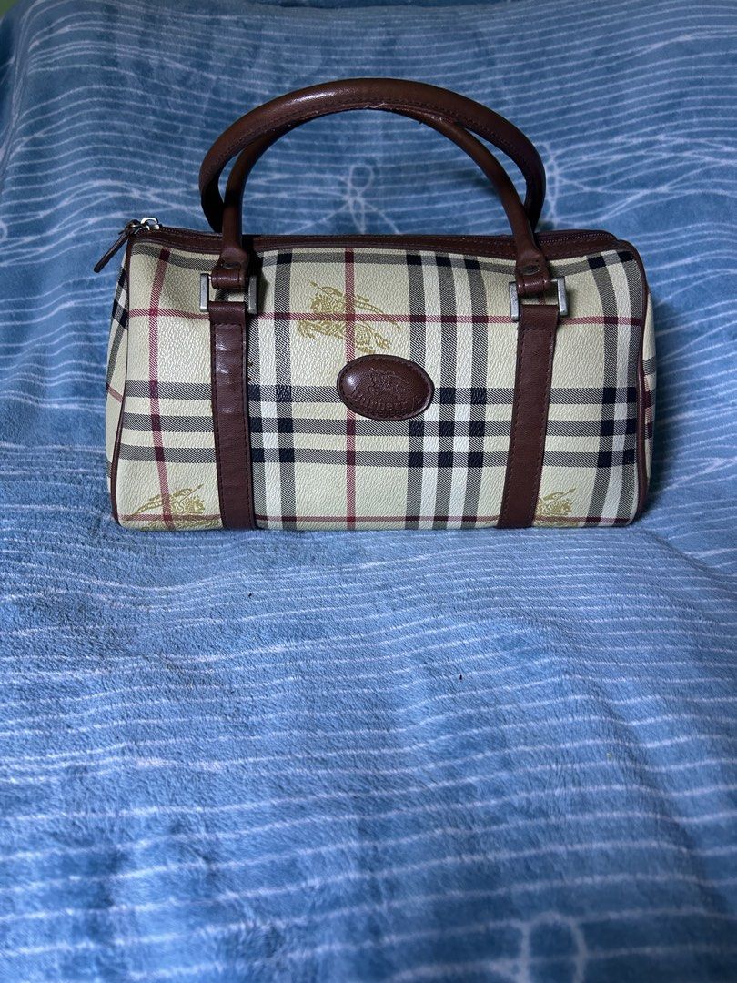 Burberrys Vintage Check Barrel Handbag (Category: Clutches) located in Quezon City. Submitted by thriftxgoods (Listing ID 1469896629, Image 1). Description: - Authentic vintage Burberrys barrel bag in iconic check print - Rich brown leather handles and trim with structured leather-paneled base - Secure top zip closure featuring an embossed leather pull tab - Signature gold equestrian knight logo on front patch and canvas - Clean interior lining e
