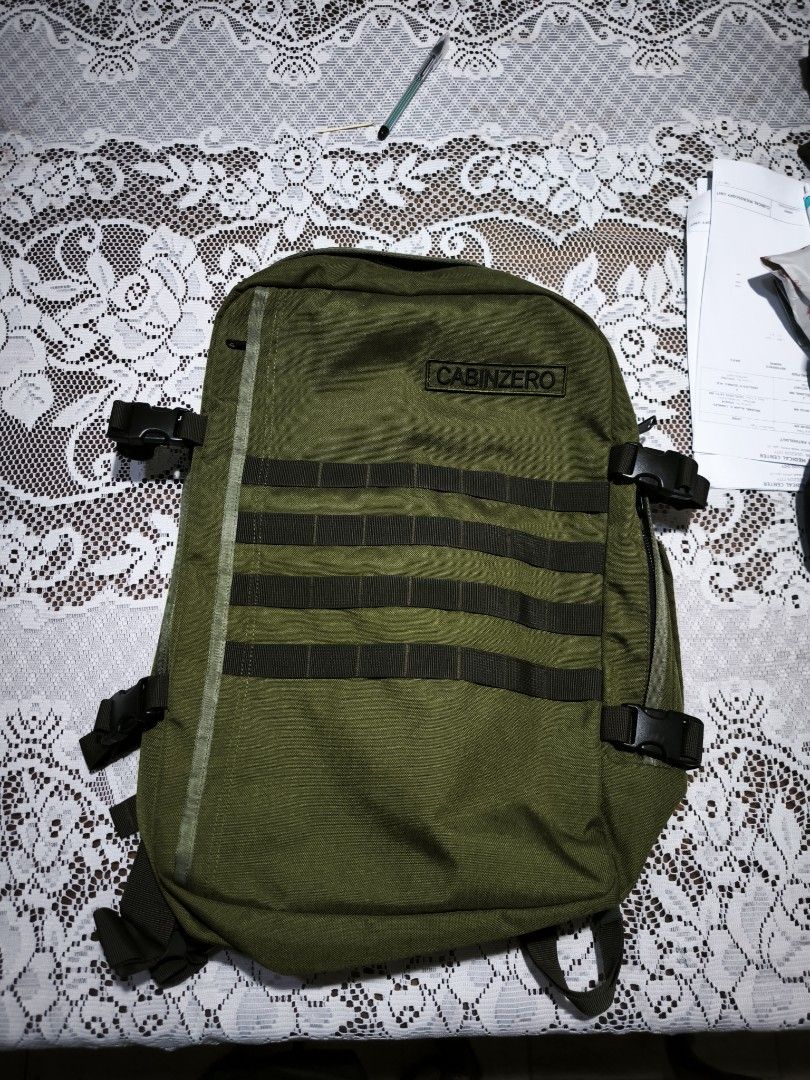 CabinZero Military 36L Backpack Green (Category: Backpacks) located in Quezon City. Submitted by dei_12 (Listing ID 1469814493, Image 1). Description: - Brand: CabinZero - Color: Green - Material: Durable nylon and polyester - Design: Front molle webbing and side compression straps with buckles - Comfort: Mesh padded shoulder straps and back panel - Interior: Wide-opening main compartment with zip pockets and mesh organizer sleeves - Condition: E