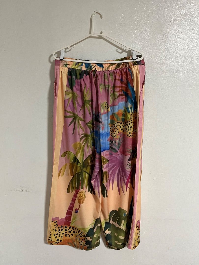 Coco Cabaña Tropical Leopard Print Wide Leg Pants (Category: Jeans) located in Cabuyao City. Submitted by rdtrmt (Listing ID 1469874865, Image 2). Description: - Brand: Cabo Cabaña - Size: XL - Design: Tropical palm tree and leopard print in bright pink, orange, and blue - Fit: Comfortable elastic waistband with a stylish wide-leg style - Fabric: Lightweight and breathable.