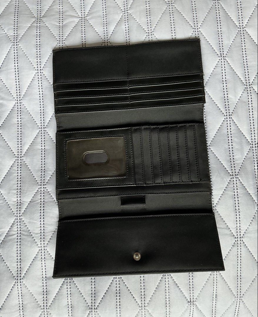 Calvin Klein Long Wallet (Category: Wallets & Card holders) located in Makati City. Submitted by boldturtle-8720 (Listing ID 1469795966, Image 3). Description: Authentic black long flap Calvin Klein wallet featuring a silver metal plaque with the Calvin Klein logo (ck Calvin Klein). Material: woven nylon .