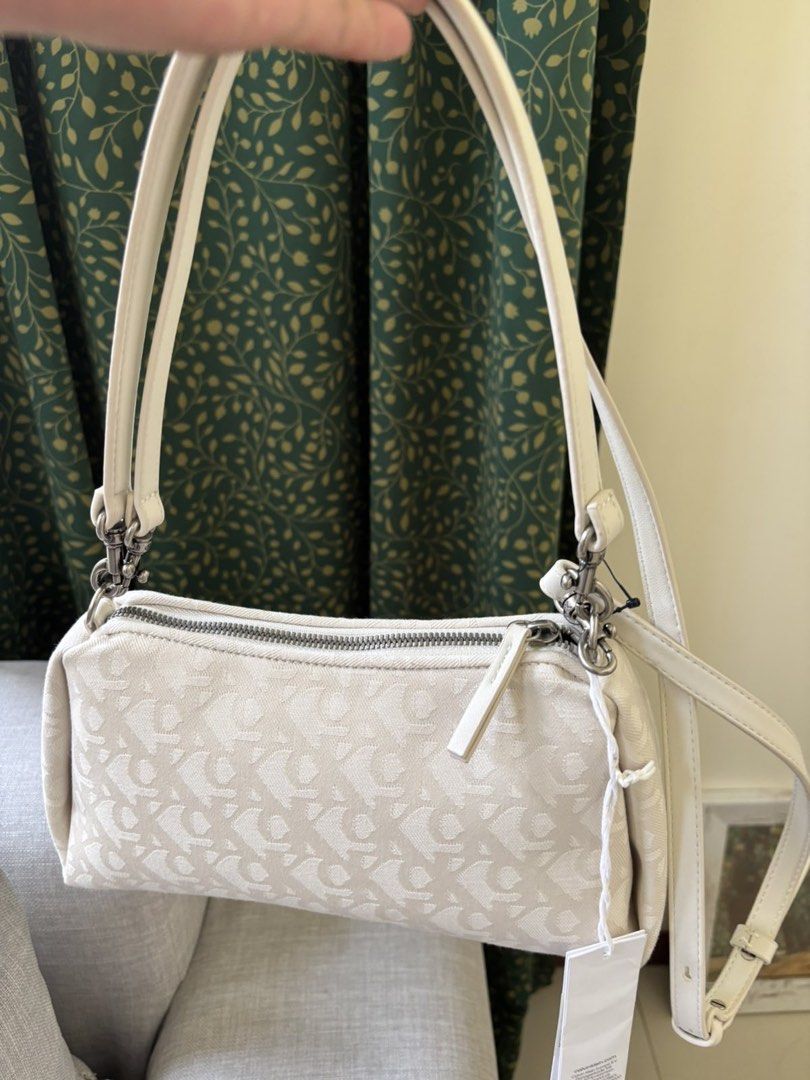 Calvin Klein monogram shoulder bag cream white (Category: Shoulder Bags) located in Paranaque City. Submitted by craftywoobieph (Listing ID 1469863495, Image 1). Description: - Authentic Calvin Klein shoulder bag in cream white with all-over monogram canvas - Brand new with original store tag still attached - Features secure top zip closure with a chunky pull tab - Stylish silver-tone metal hardware and lobster clasps - Versatile design includes 