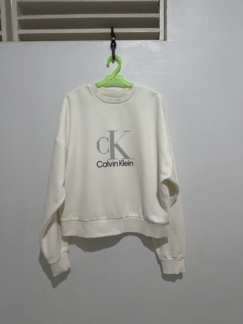 Calvin Klein Textured Sweatshirt (Category: Coats, Jackets and Outerwear) located in Cainta. Submitted by xyzasisa (Listing ID 1469910229, Image 1). Description: - Brand: Calvin Klein - Color: Off-white - Size: US Small / Asia Medium (Chest 80A) - Material: 72% Cotton, 28% Polyester - Design: Large dotted CK logo on front with printed text below - Fit: Drop shoulder, relaxed fit with ribbed collar, cuffs, and hem - Origin: Made in Kenya - Conditi