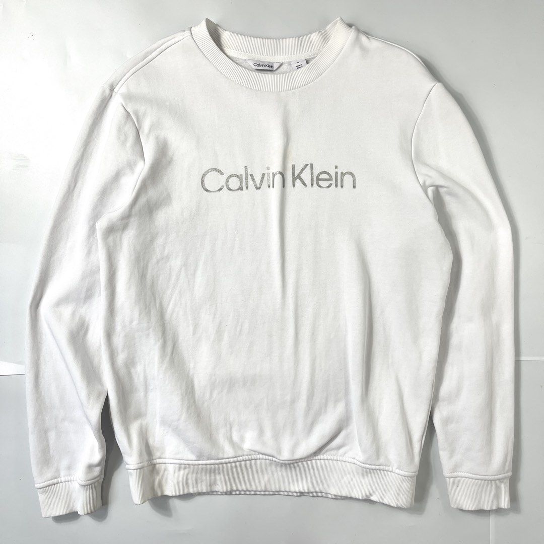 Calvin Klein White Crewneck Sweater (Category: Coats, Jackets and Outerwear) located in Nasugbu. Submitted by janstuffs.ph (Listing ID 1469853375, Image 1). Description: 💯Legit! Size: Medium on tag Width: 21" Length: 26" Sleeve: 25" Condition: 10/10 Like New Flaw: NONE Mine: 1080.