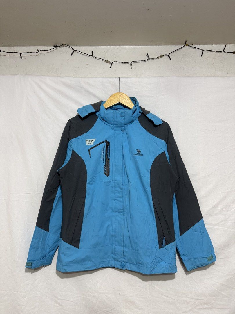 Camel Kids Blue Grey Outdoor Jacket (Category: Coats, Jackets and Outerwear) located in Quezon City. Submitted by dapanaaaay (Listing ID 1469927456, Image 1). Description: - Color: Bright blue with dark grey shoulder and side panels - Features: Front zipper pocket, high collar, and attached hood - Branding: Embroidered logo on the chest - Ideal for: Outdoor trips, adventures, or chilly days - Condition: Great outerwear choice.