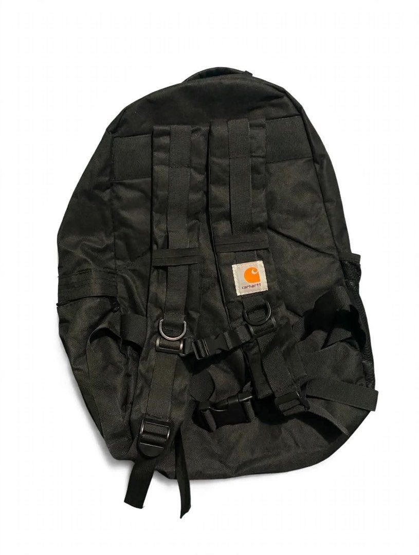 Carhartt Black Backpack with Front Straps and Mesh Pocket (Category: Backpacks) located in Quezon City. Submitted by un0oo (Listing ID 1469923747, Image 2). Description: FAKE Carhartt backpack in solid black. Tough fabric holds up well. Front features two buckle strap rows and a bungee cord system. Mesh pocket on the side for a water bottle or small items. Padded shoulder straps include adjustable chest and waist buckles for secure carrying. Logo