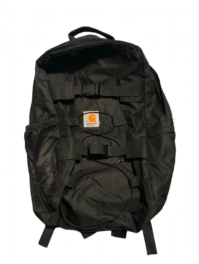 Carhartt Black Backpack with Front Straps and Mesh Pocket (Category: Backpacks) located in Quezon City. Submitted by un0oo (Listing ID 1469923747, Image 1). Description: FAKE Carhartt backpack in solid black. Tough fabric holds up well. Front features two buckle strap rows and a bungee cord system. Mesh pocket on the side for a water bottle or small items. Padded shoulder straps include adjustable chest and waist buckles for secure carrying. Logo