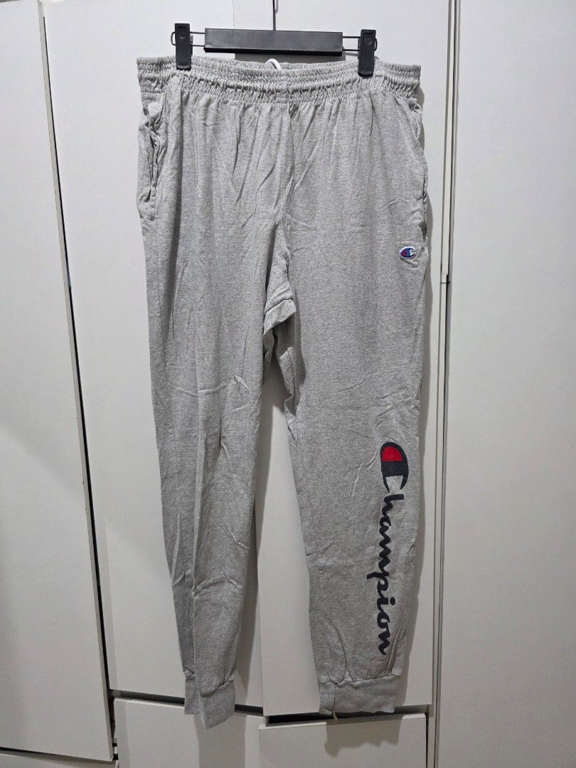 Champion Grey Joggers Sweatpants Size L (Category: Joggers) located in Manila. Submitted by arjoylagazon (Listing ID 1469898053, Image 1). Description: Grey Champion sweatpants with large script logo down the left leg and small embroidered logo patch near the waistband. Elastic drawstring waist and ribbed cuffs at the ankles. Tag shows size L. Made in Honduras. Comfortable cotton blend material, great for lounging or casual wear..