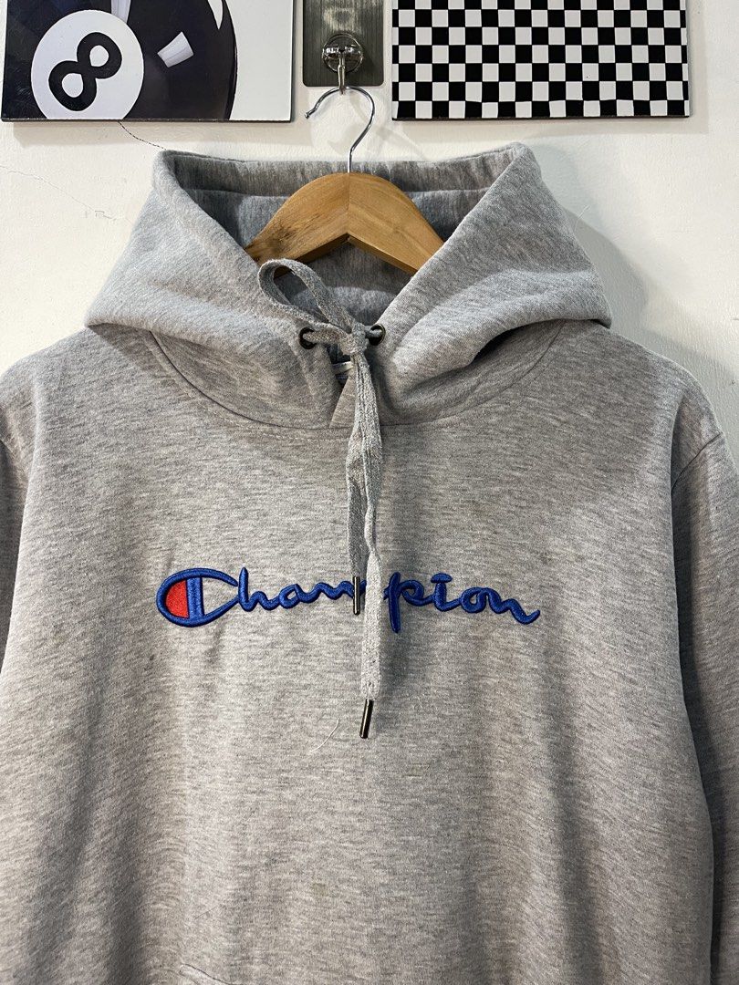 Champion Grey Script Logo Hoodie XX-Large (Category: Hoodies) located in Cabagan. Submitted by blessingma81004 (Listing ID 1469767471, Image 3). Description: - Brand: Champion - Color: Grey with embroidered blue script logo - Features: Kangaroo front pocket, adjustable drawstring hood - Size: Tagged XX-Large (fits like a Medium-Large based on measurements).