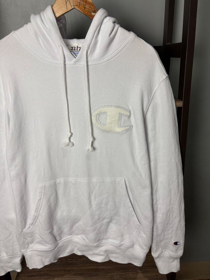 Champion White Hoodie XXLarge (Category: Hoodies) located in Manila. Submitted by thriftnikenv.2 (Listing ID 1469865277, Image 2). Description: - Brand: Champion - Size: XXLarge (2XL) - Color: Classic White - Material: 100% Cotton (Made in Indonesia) - Design: Large chenille C logo patch on the chest - Details: Kangaroo front pocket, drawstring hood, ribbed cuffs, and embroidered sleeve patch - Condition: Excellent, ready to wear.