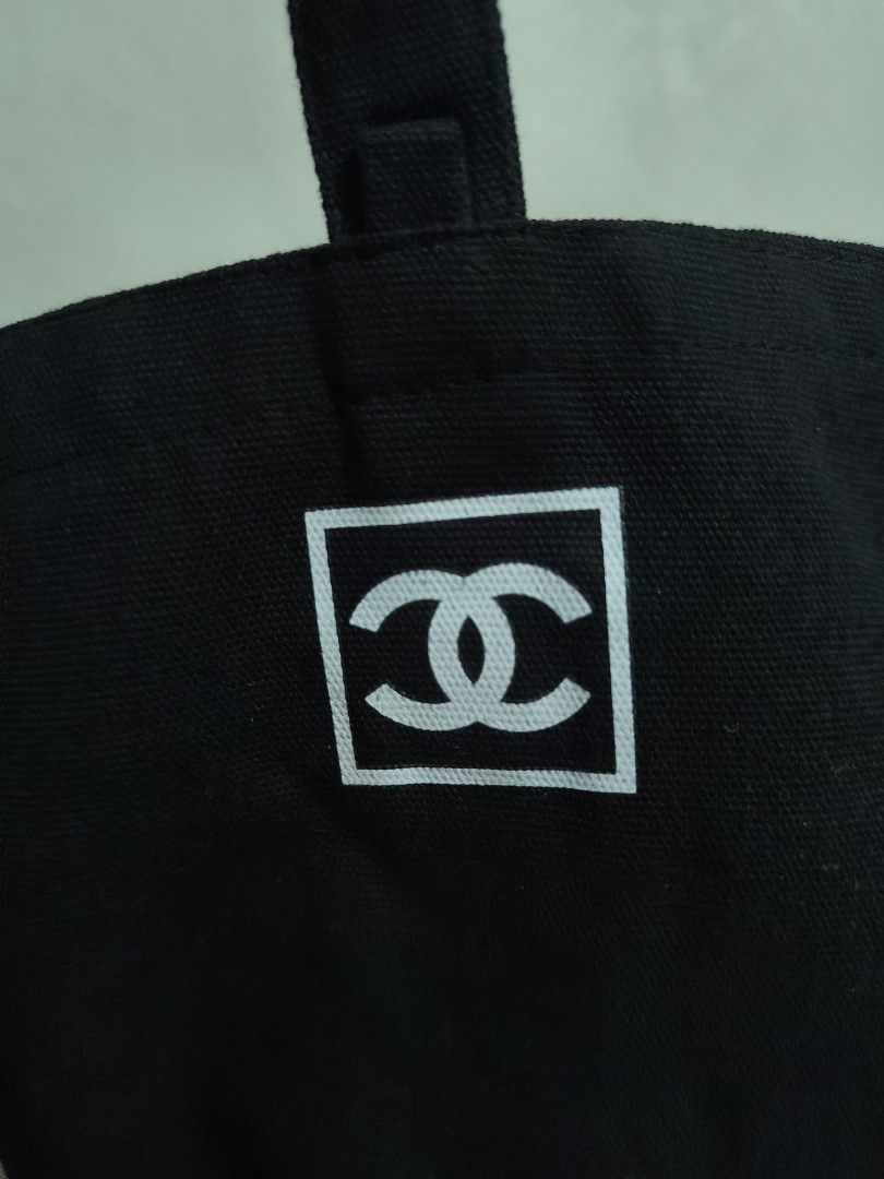 Chanel Black Canvas Tote Bag (Category: Tote Bags) located in Taytay. Submitted by bunsoanglo096 (Listing ID 1469878204, Image 3). Description: - Authentic-style black canvas tote bag - Bold white Chanel CC logo inside a front square patch - Single top handle with woven lettering design and small vertical Chanel label - Clean structure with durable and sturdy fabric construction - Spacious daily carryall, ideal for casual lakad and daily use.