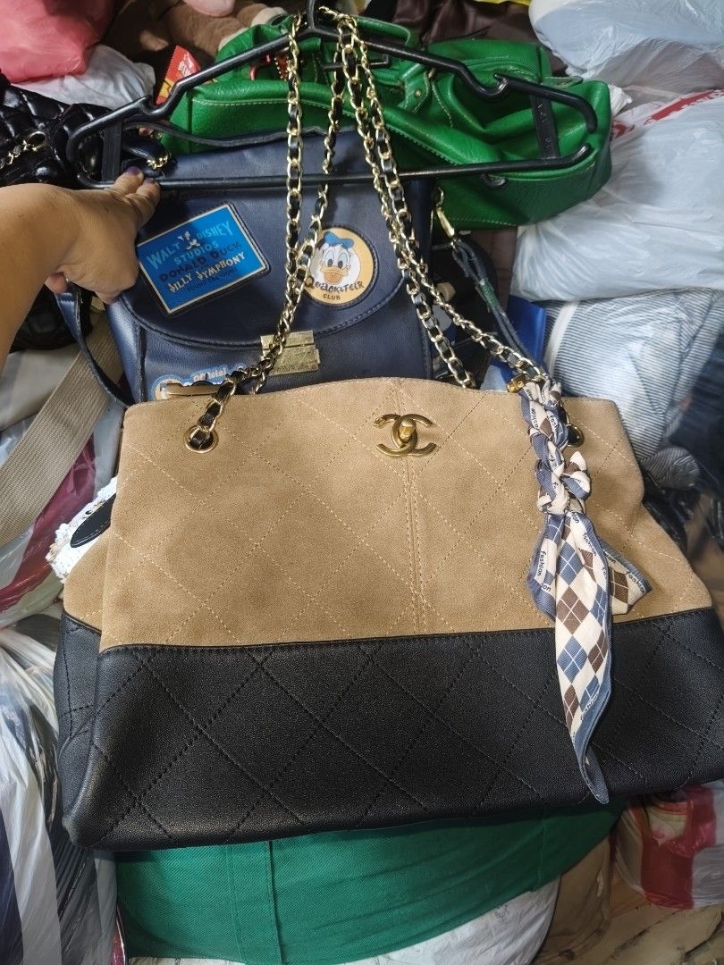 Chanel Two-Tone Suede and Leather Handbag (Category: Luxury Bags & Wallets) located in Manila. Submitted by arlene.07 (Listing ID 1469773567, Image 2). Description: - Material: Premium tan suede and black leather with gold-tone hardware - Design: Elegant quilted pattern featuring a front CC logo - Interior: Black fabric lining with a convenient zippered pocket and brand tag - Strap: Stylish chain handles accented with a removable patterned scarf 