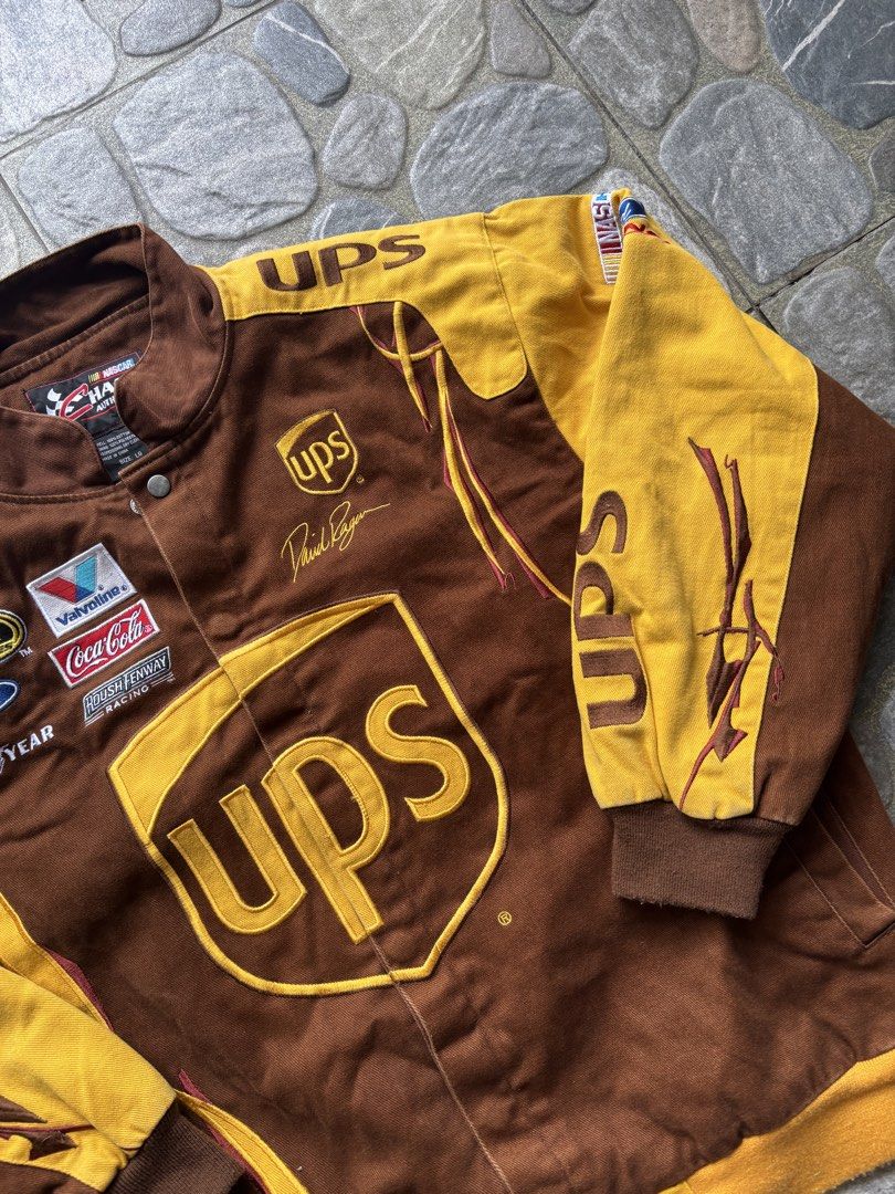 Chase Authentics NASCAR UPS David Ragan Racing Jacket Size L (Category: Coats, Jackets and Outerwear) located in Naga. Submitted by prime.ledesma (Listing ID 1469904950, Image 3). Description: - Brand: Chase Authentics - Driver Edition: David Ragan (#6 UPS) - Color: Brown and Yellow - Size: Large - Material: 100% cotton shell with 100% polyester lining - Closure: Snap button - Details: Multiple embroidered sponsor patches (Sprint, Ford, Valvoline