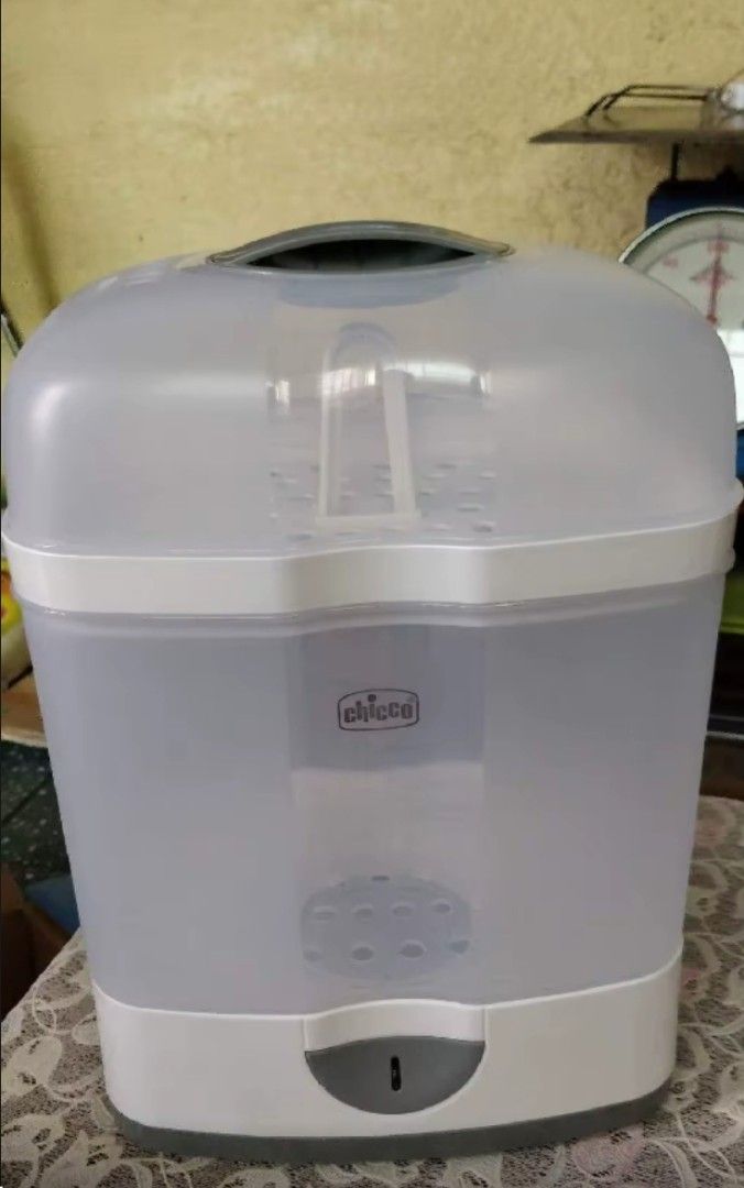 Chicco Safe and Simple Bottle Sterilizer (Category: Breastfeeding & Bottle Feeding) located in Manila. Submitted by kelly_store2 (Listing ID 1469791871, Image 2). Description: - Brand: Chicco - Color: White and translucent grey - Large capacity fits multiple bottles and small parts simultaneously - Easy one-touch power button operation - Compact footprint saves valuable kitchen counter space.