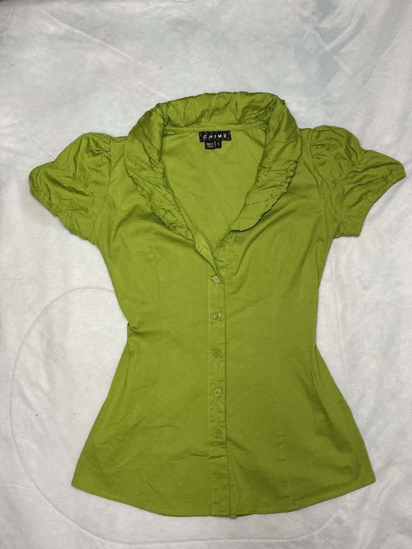 Chime Green Ruffle Collar Button Up Blouse Size S (Category: Blouses) located in Binan City. Submitted by myks_thrift (Listing ID 1469900873, Image 1). Description: - Brand: Chime - Size: Small (has stretch) - Color: Green - Material: 97% cotton, 3% spandex - Style: Button-up, ruffle collar, short puff sleeves, fitted waist - Condition: Clean and ready to wear.