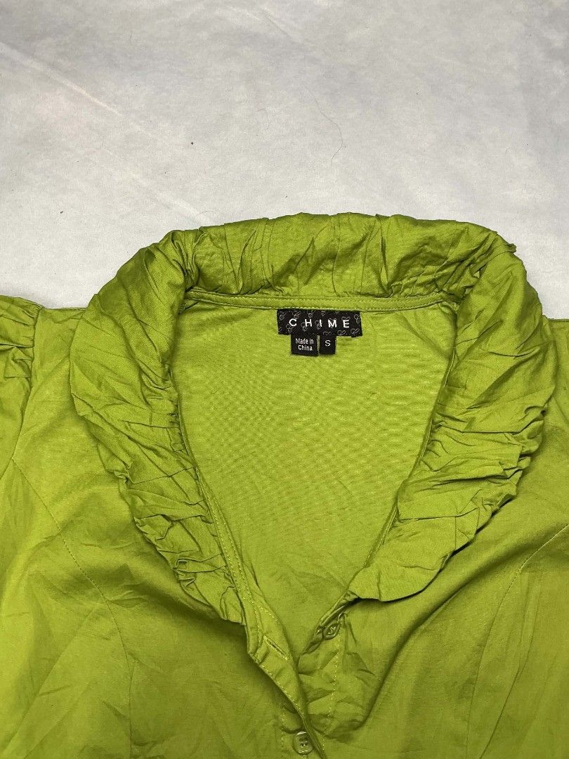 Chime Green Ruffle Collar Button Up Blouse Size S (Category: Blouses) located in Binan City. Submitted by myks_thrift (Listing ID 1469900873, Image 2). Description: - Brand: Chime - Size: Small (has stretch) - Color: Green - Material: 97% cotton, 3% spandex - Style: Button-up, ruffle collar, short puff sleeves, fitted waist - Condition: Clean and ready to wear.